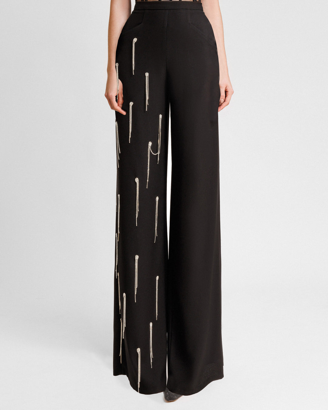 A straight-cut black pants featuring beading fringes on a single leg.