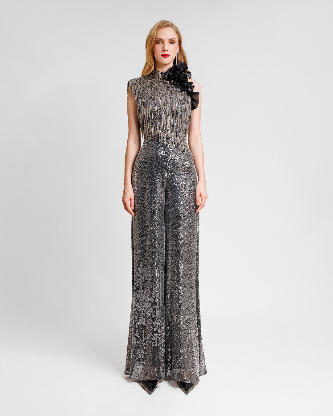 An asymmetrical neckline jumpsuit with an embroidered bodice and floral draping on the shoulder.