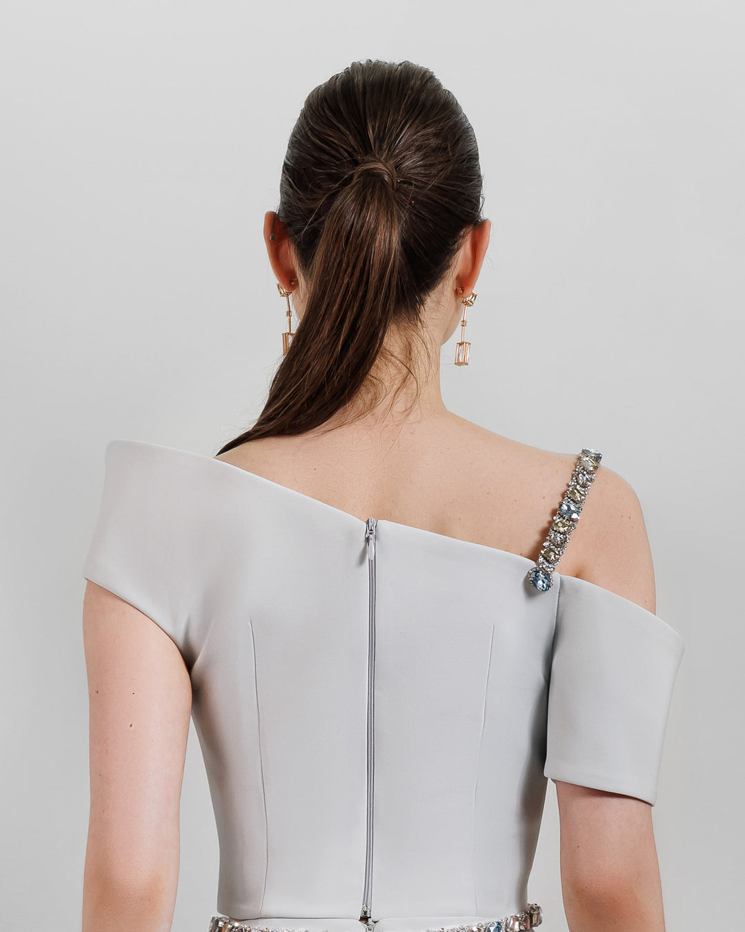 The back of an asymmetrical neckline top with a beaded strap.