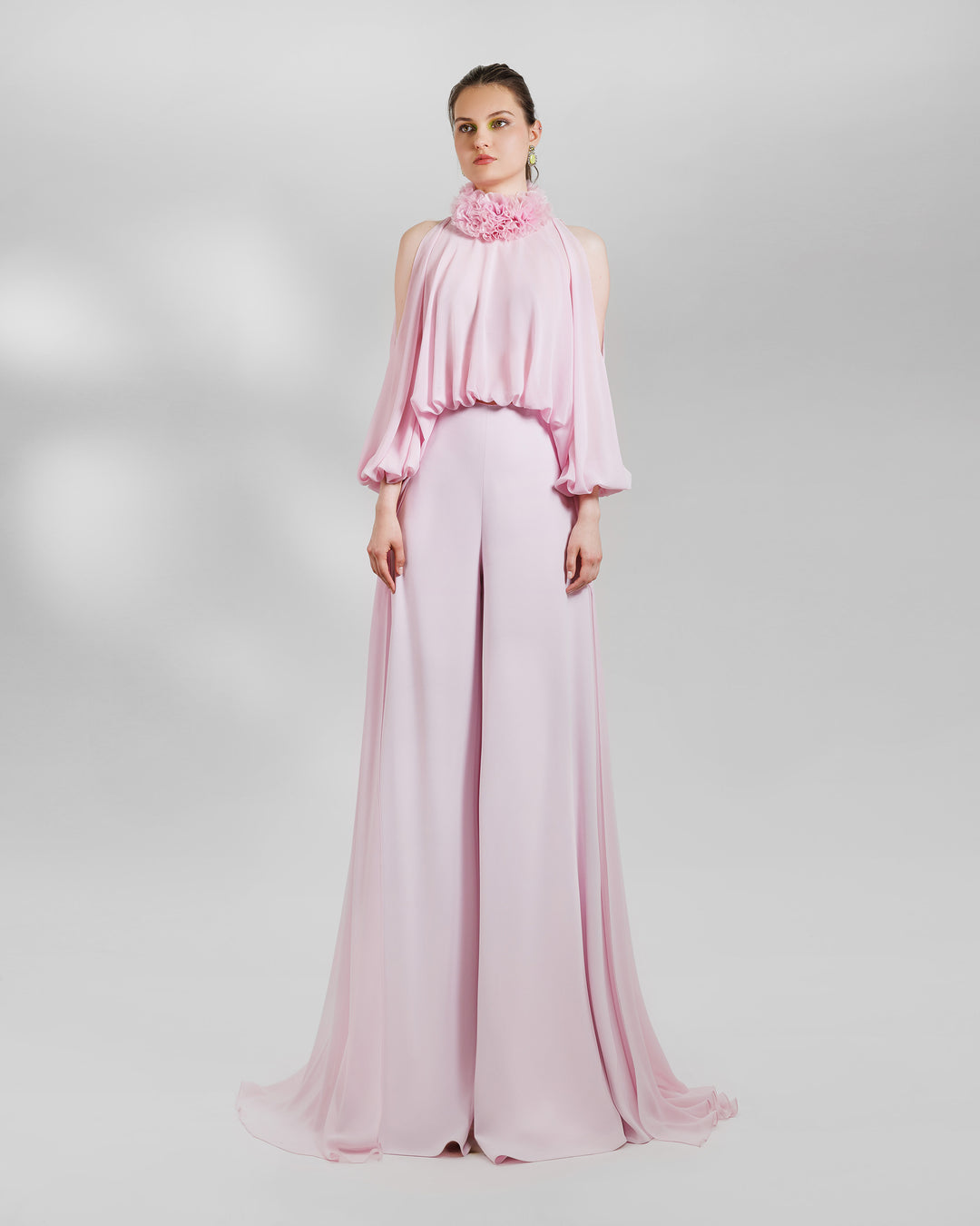 An evening wear pink set featuring organza high-collar top with open shoulders and a long back, paired with wide high-waist pants.