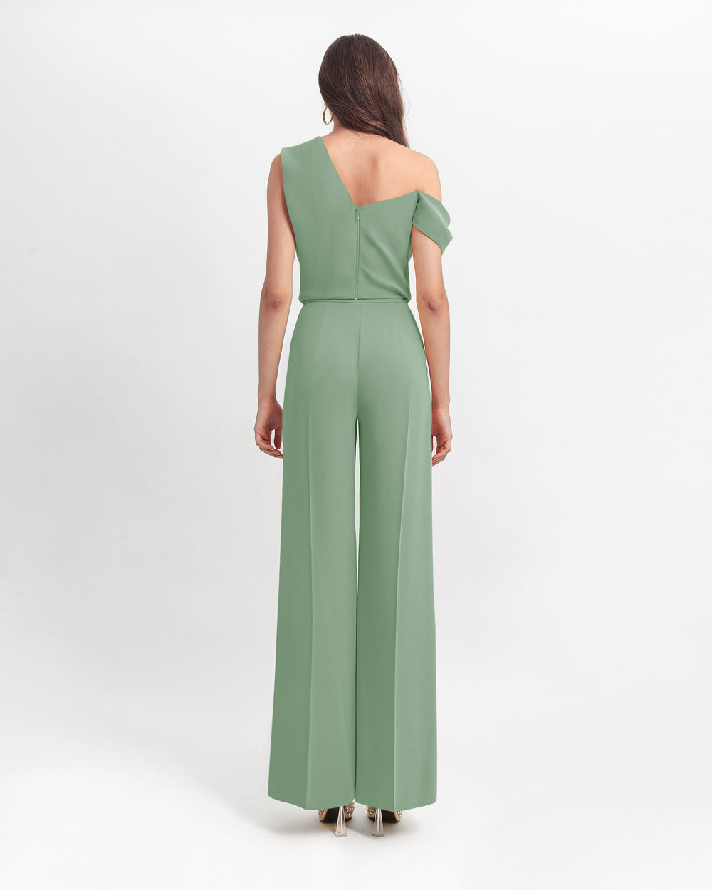 The back of an asymmetrical cut crepe green top with draping details, paired with a straight cut green crepe pants.