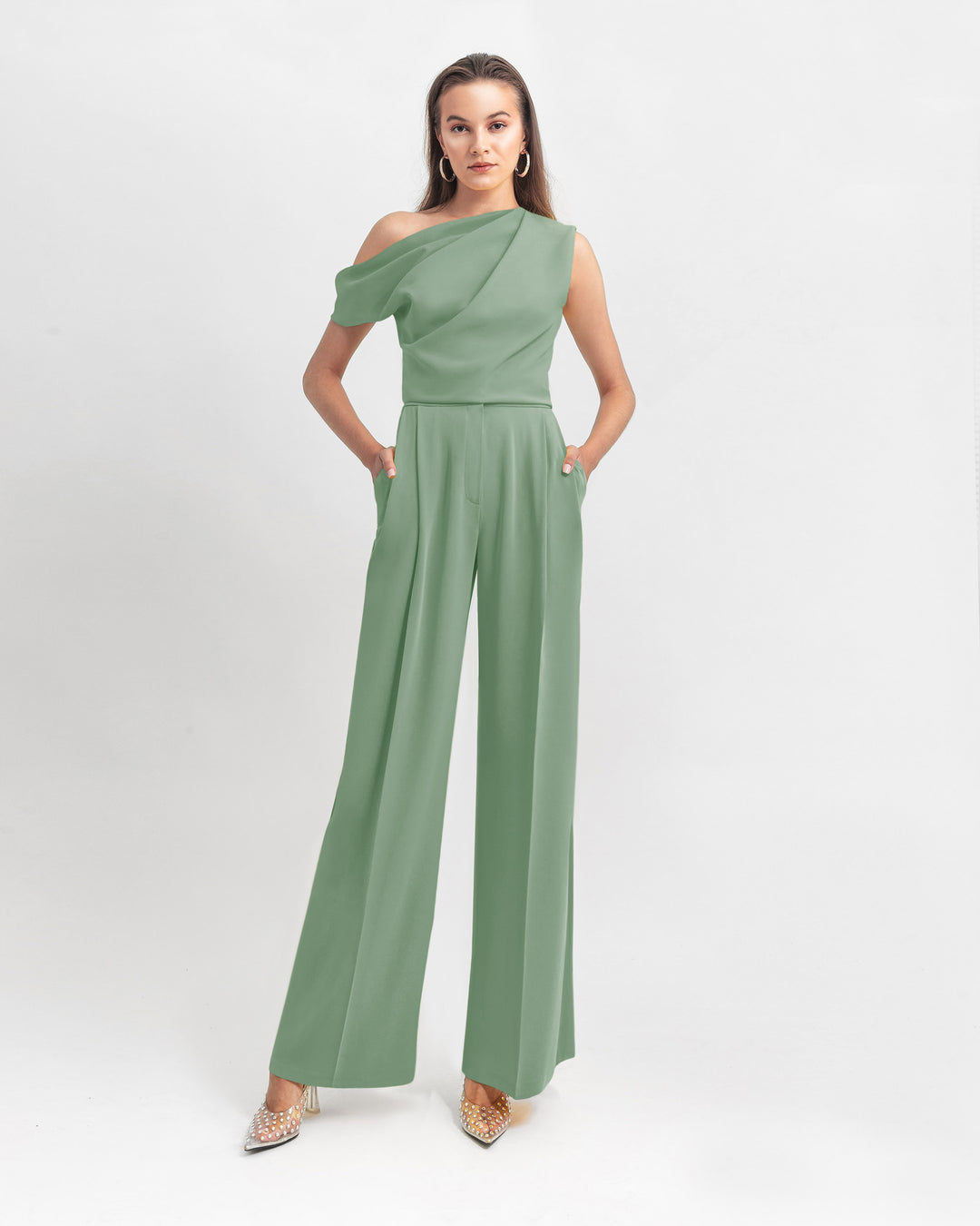 An asymmetrical cut crepe green top with draping details, paired with a straight cut crepe pants.