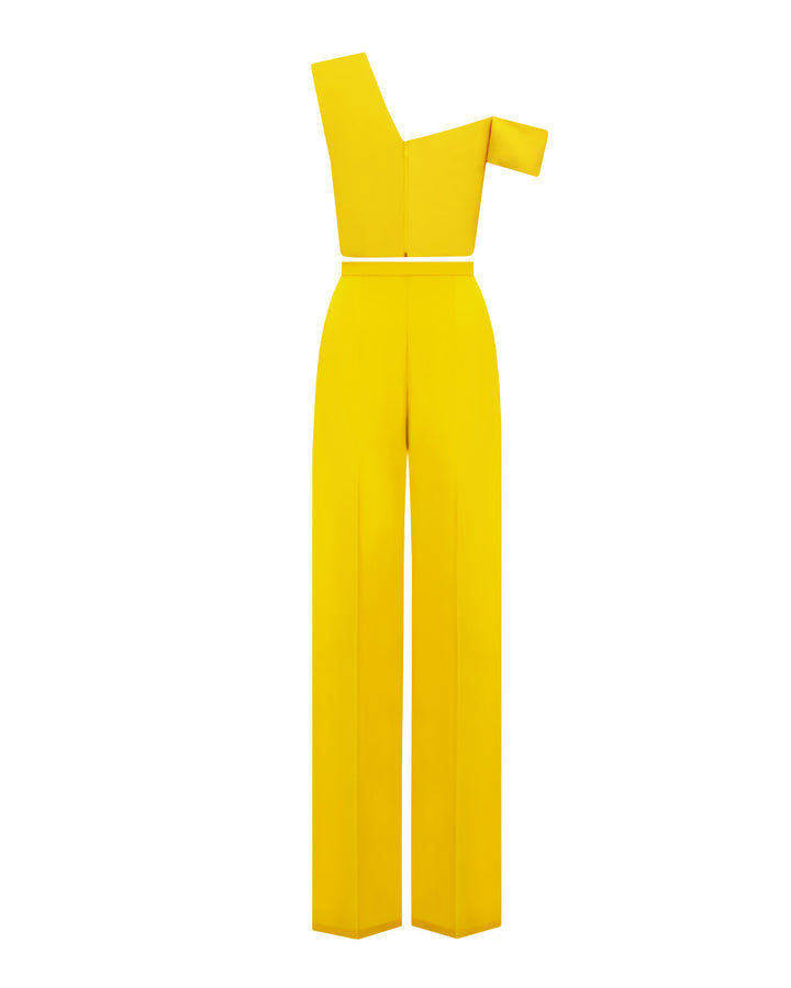 The back of a yellow evening wear set featuring an asymmetrical cut crepe top with draping details, paired with a straight cut crepe pants.