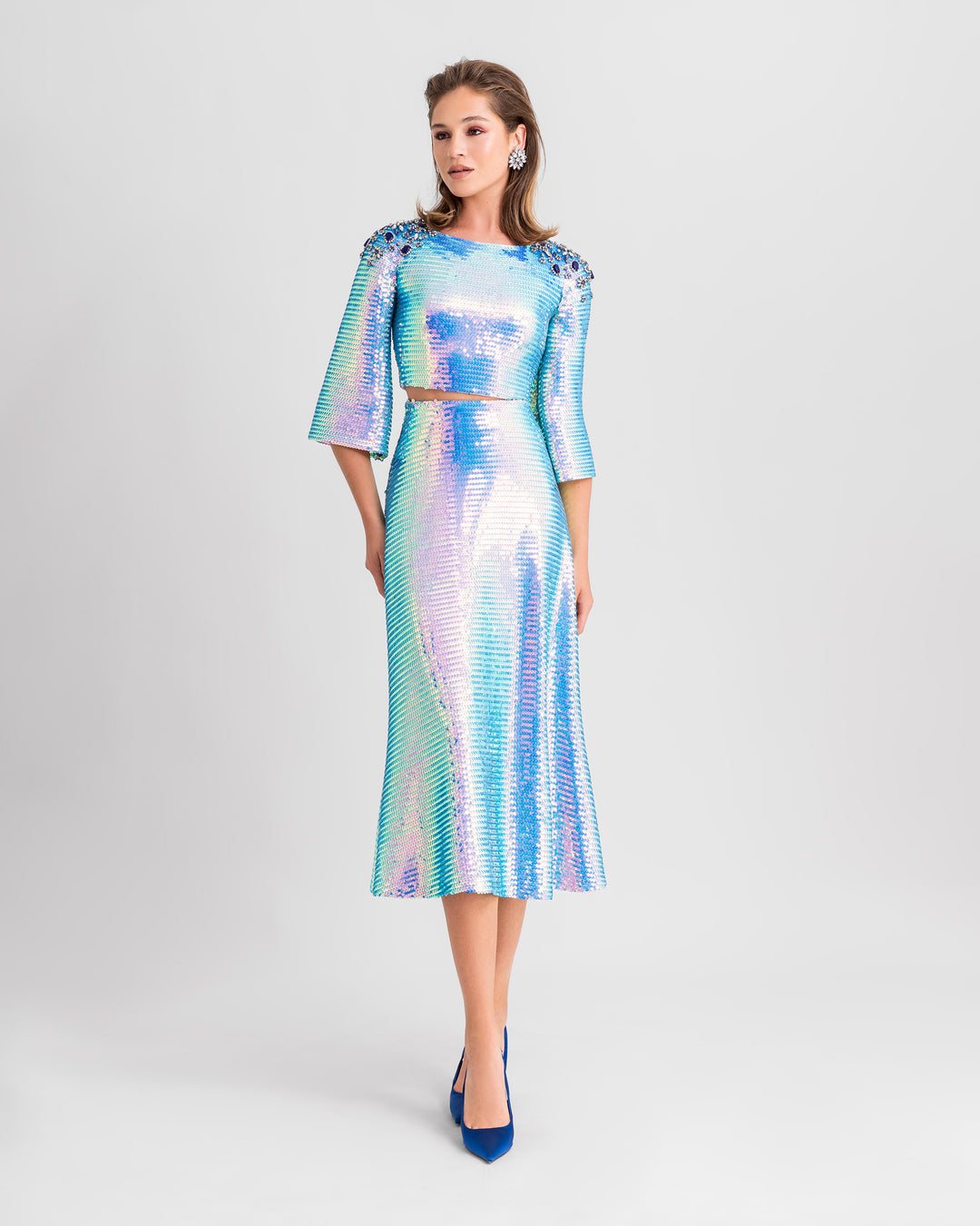 A blue sequined evening wear set featuring a sleeved cropped-top with beaded shoulders paired with a flared midi skirt.