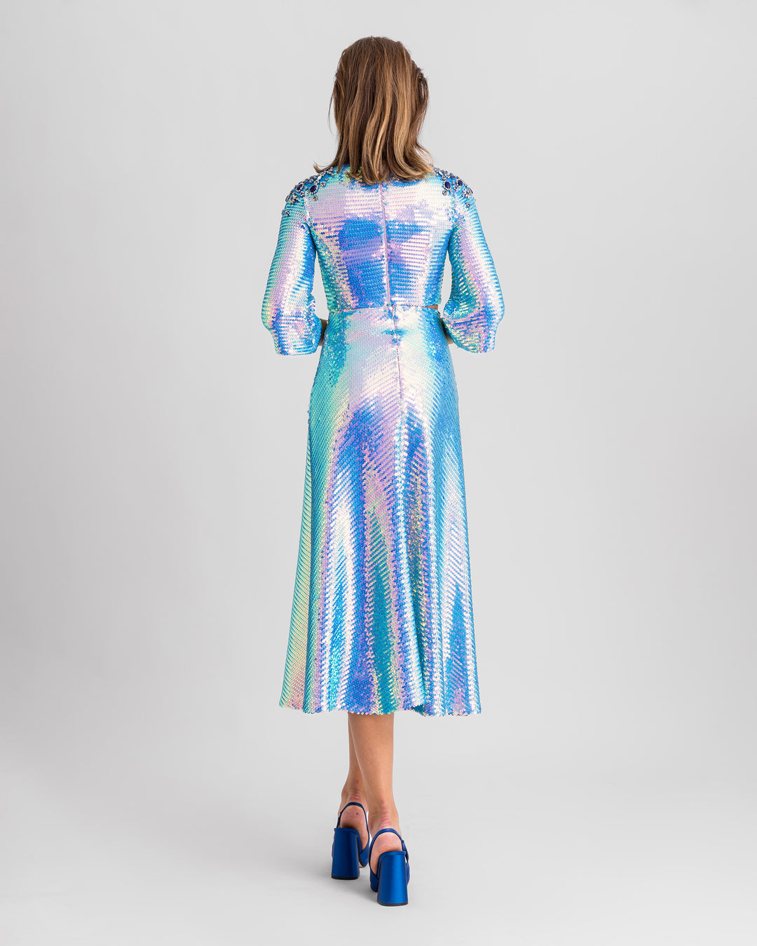 The back of a blue sequined evening wear set featuring a sleeved cropped-top with beaded shoulders paired with a flared midi skirt.