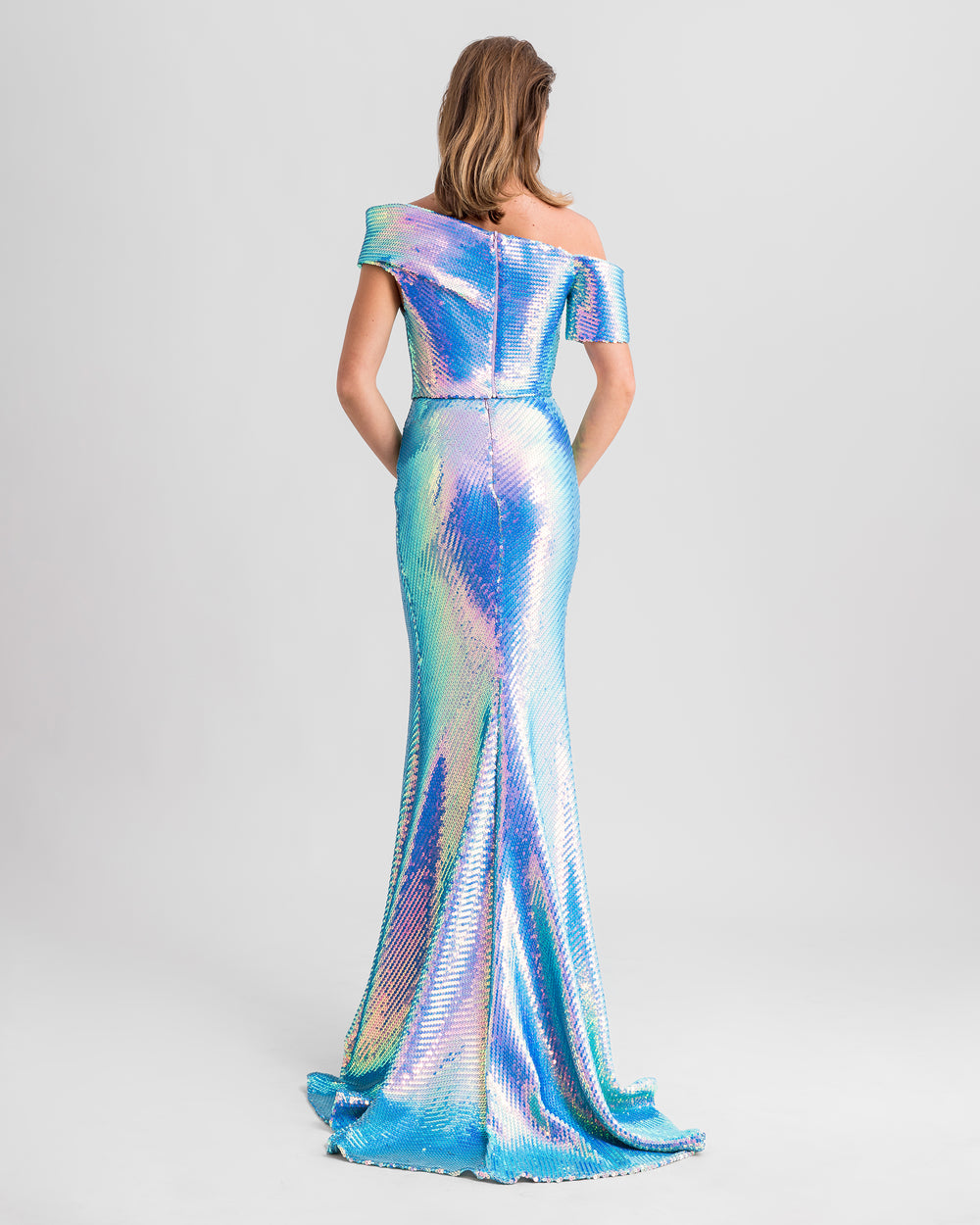 The back of a blue sequined evening wear set featuring an asymmetrical one-shoulder draped top paired with a long slim-cut skirt.