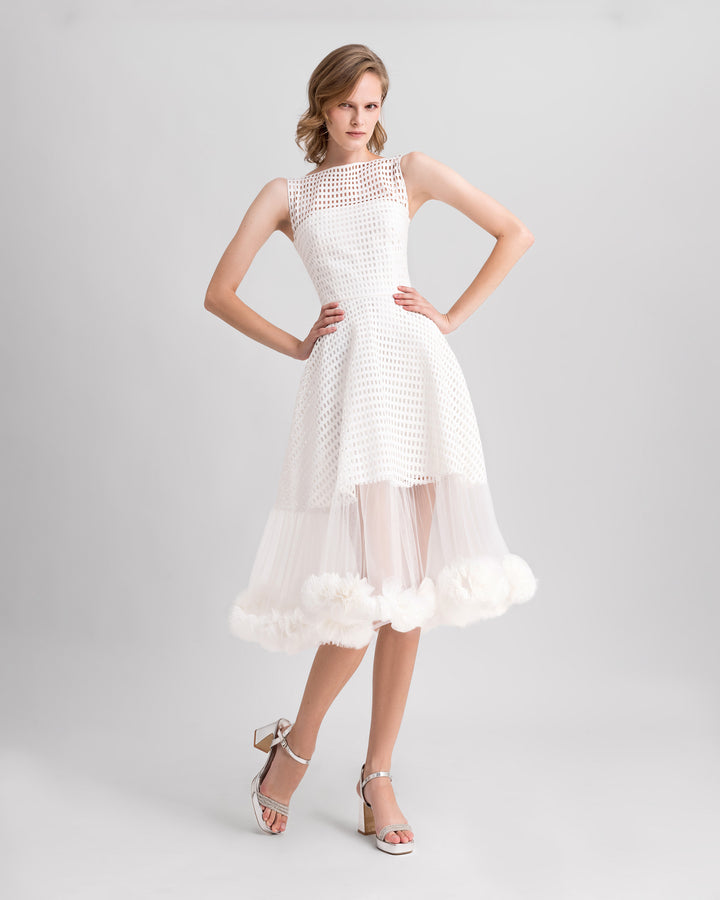 An ivory crochet lace flared midi dress with rushed tulle on the hemline.