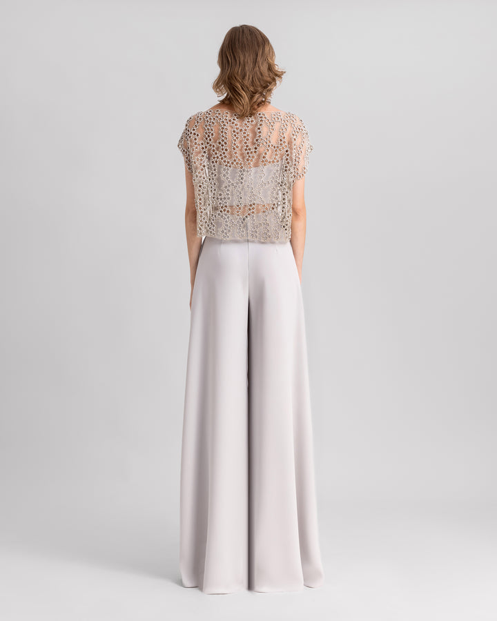 The back of a grey evening wear set featuring an embroidered tulle top paired with straight-cut pants.