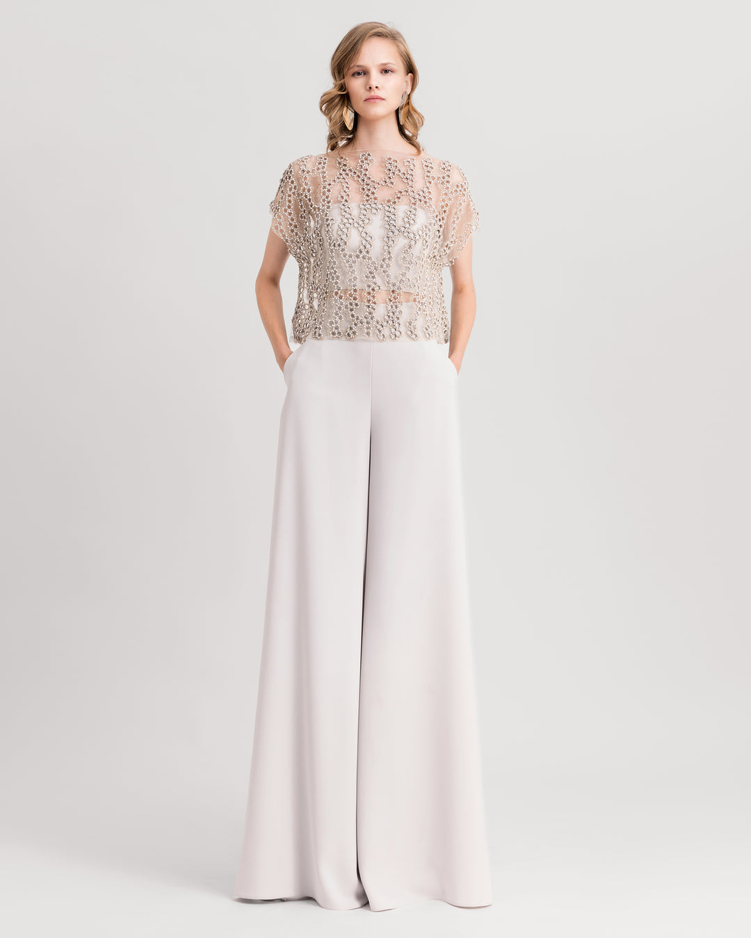 A grey evening wear set featuring an embroidered tulle top paired with straight-cut pants.