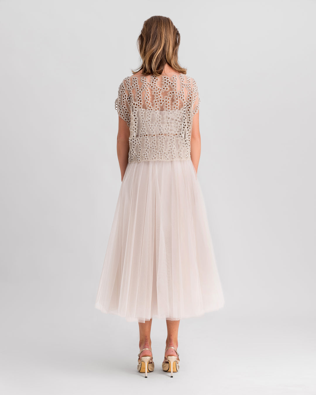 The back of a grey evening wear set featuring an embroidered tulle top paired with a midi tulle skirt.