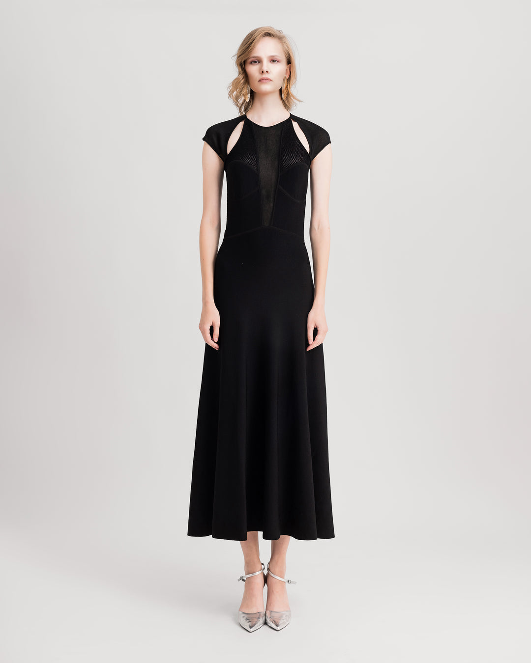 A black flared midi knit dress featuring cut-outs on the shoulders and a long v-neckline.