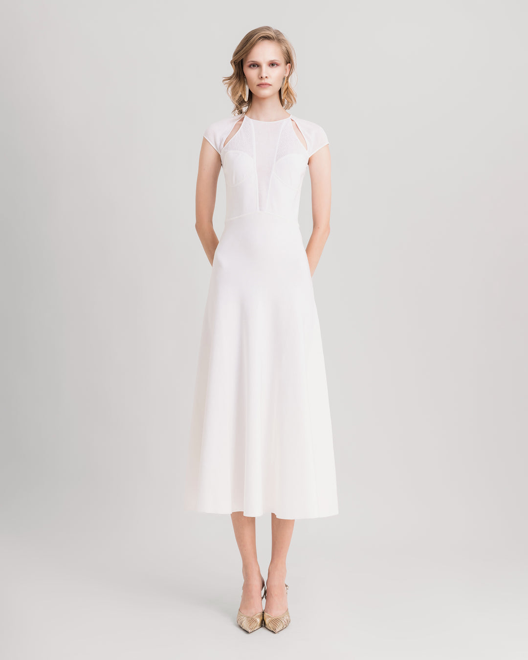 A white midi knit dress featuring cut-outs on the shoulders and a deep v-neckline.