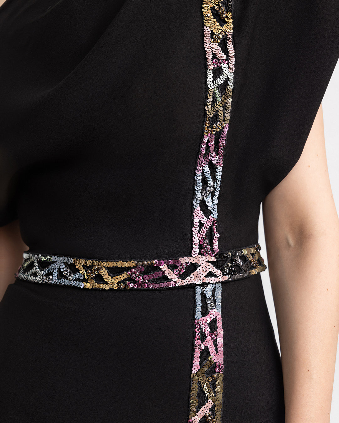 A close-up of a multicored beading details on a black crepe evening dress.