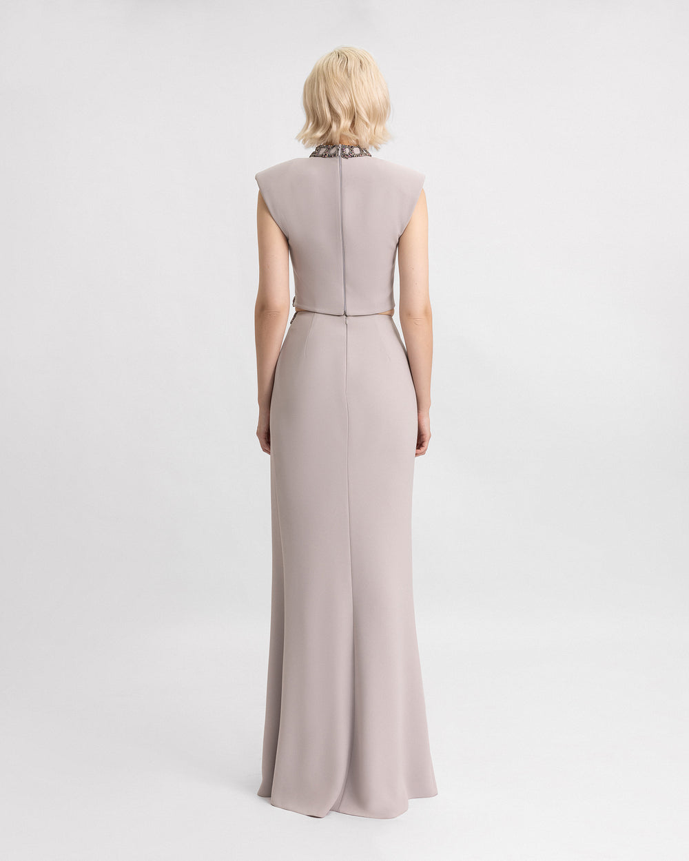 The back of a grey evening wear set featuring beaded high-collar top with structured shoulders paired with a matching crepe skirt.