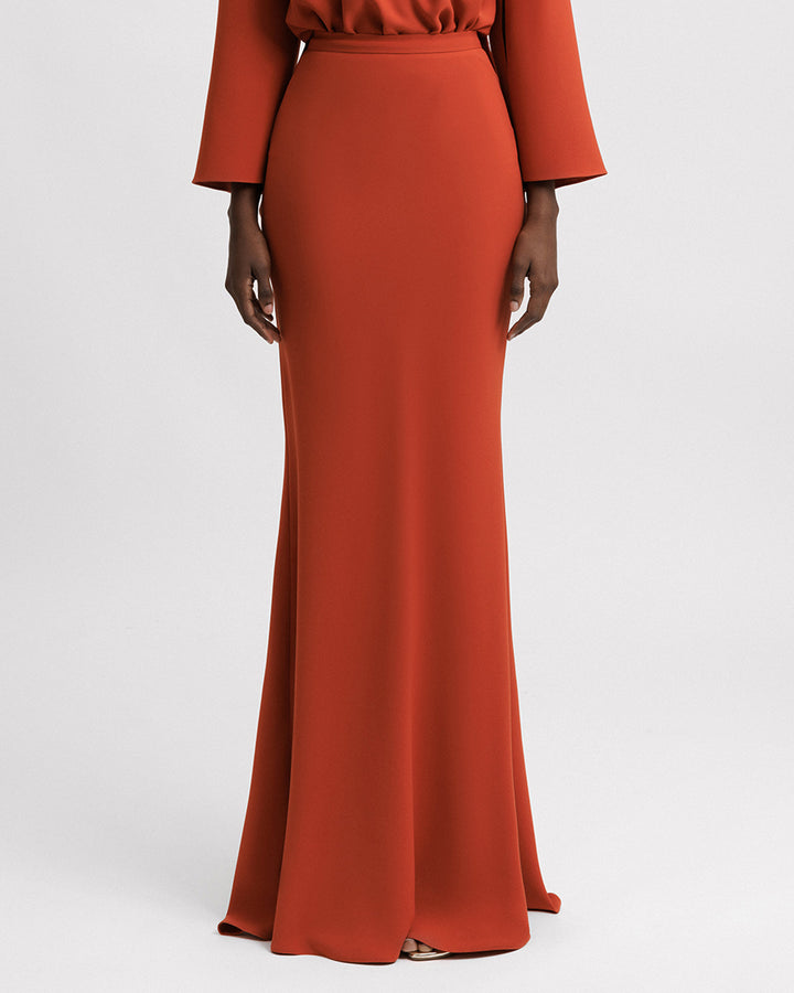 An evening wear slim-cut long crepe skirt in orange color.