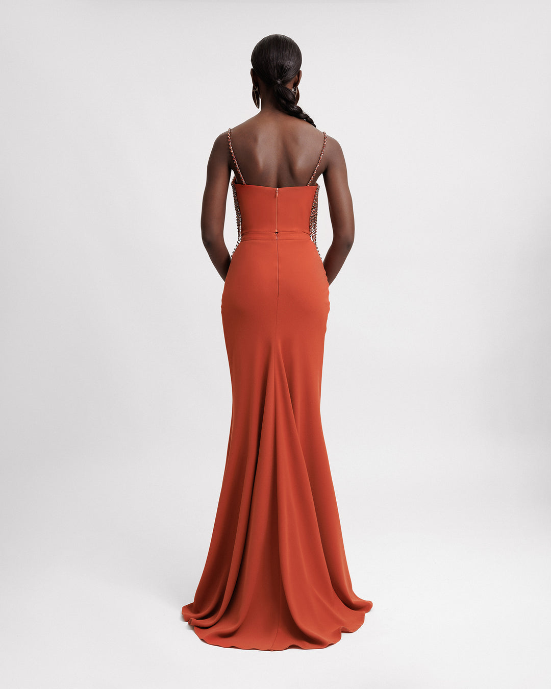 The back of an evening wear set featuring a beaded straps top in copper color paired with a slim-cut long crepe skirt.