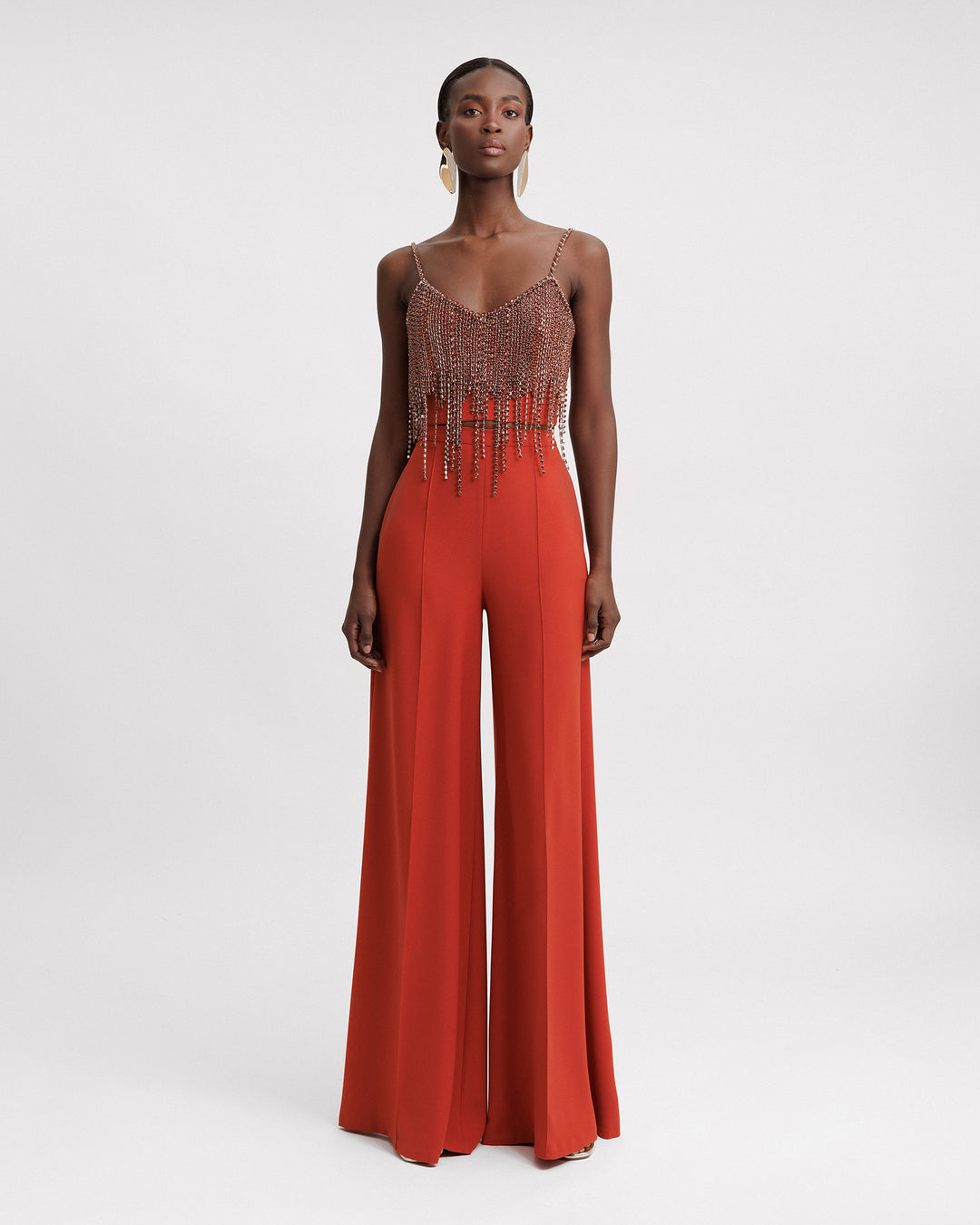 An evening wear set featuring a beaded tassels cropped top in copper paired with a flared pants.