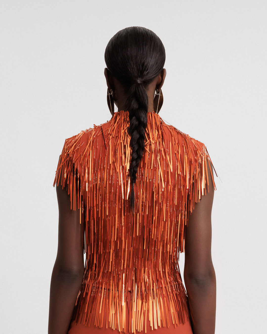 The back of an evening wear high-collar beaded fringes top in copper color.