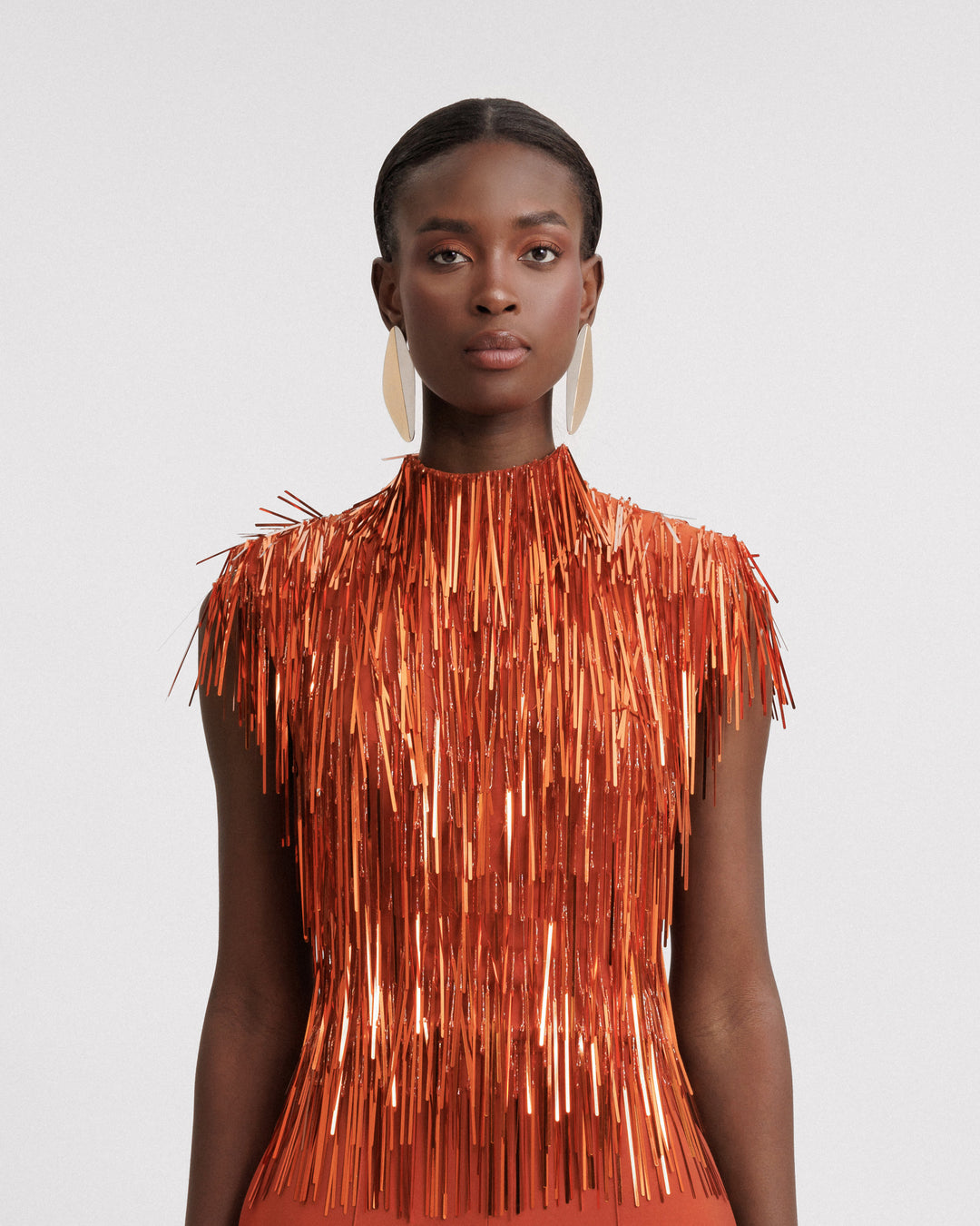 An evening wear high-collar beaded fringes top in copper color.