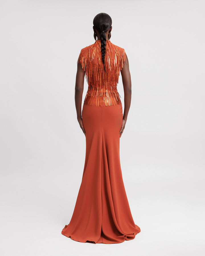 The back of an evening wear set featuring a high-collar beaded fringes top in copper color paired with a slim-cut crepe long skirt.