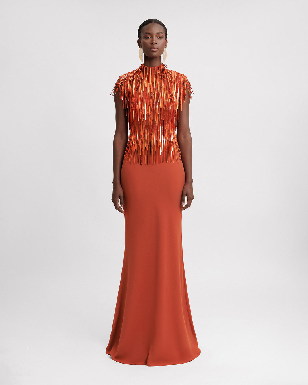 An evening wear set featuring a high-collar beaded fringes top in copper color paired with a slim-cut crepe long skirt.