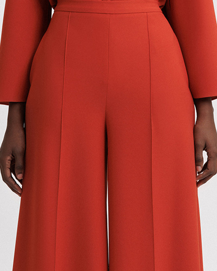 A close-up of an evening wear flared orange pants.