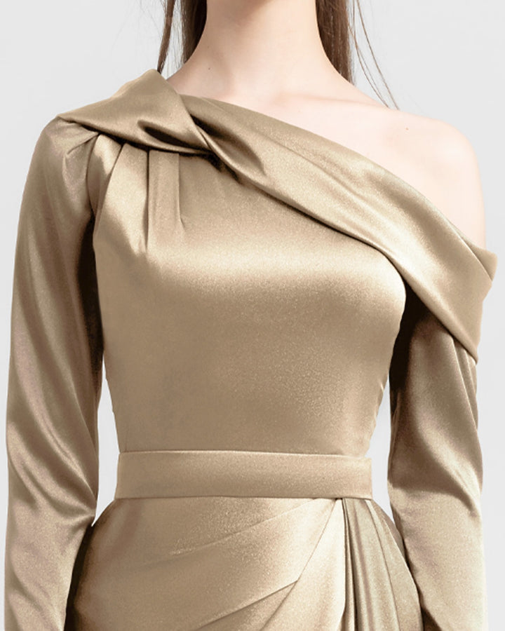 A close-up of a slim-cut gold satin evening dress featuring an asymmetrical draped neckline and draping details on the waist.