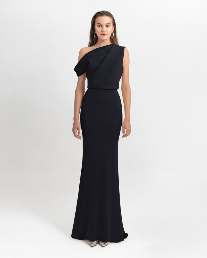 An Asymmetrical cut crepe long black dress with draping details on the upper part and a slim cut skirt.