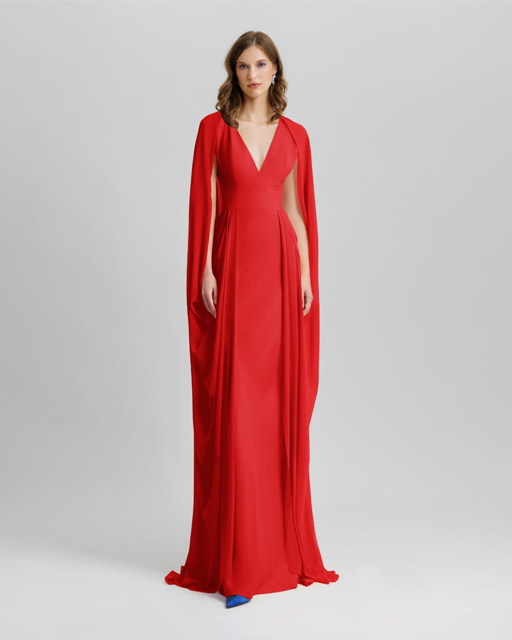 A V-neckline long evening red dress with cape-like draped sleeves.