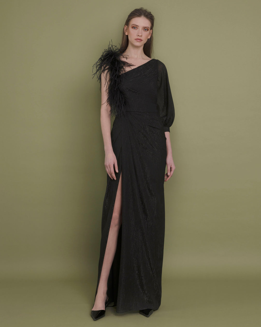 An asymmetrical neckline chiffon black evening dress with feather sleeve, draping and open slit on the side.