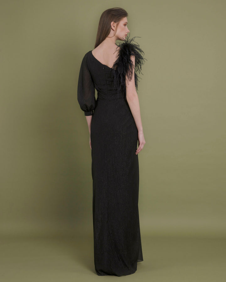 The back of an asymmetrical neckline chiffon black evening dress with feather sleeve, draping and open slit on the side.