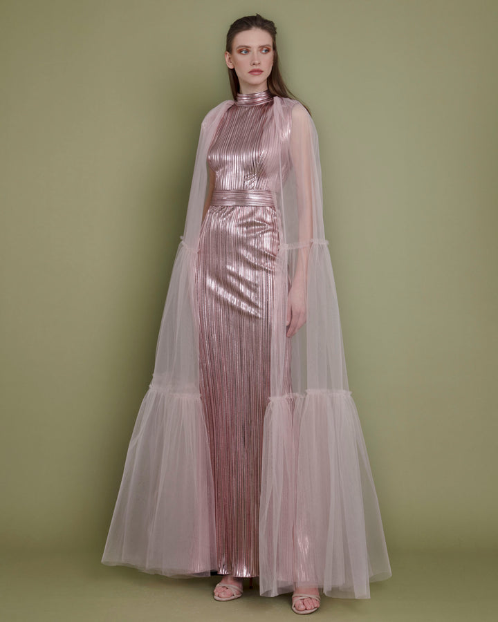 A slim cut metallic pink evening dress in pleated fabric paired with a tulle ruffled cape.