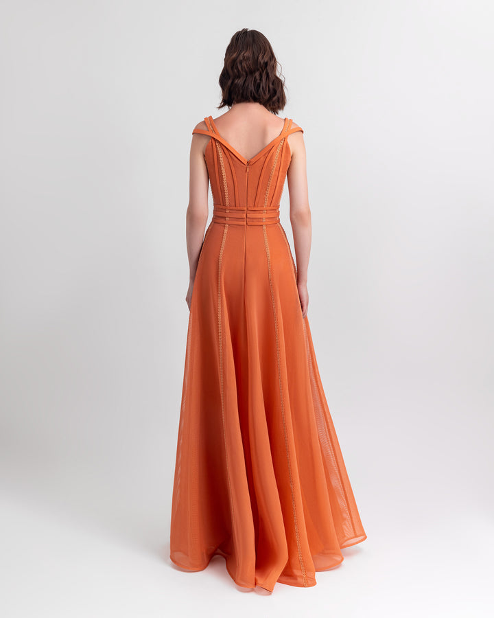 The back of a corset flared mesh orange dress with embroidery details and three stipes belt.