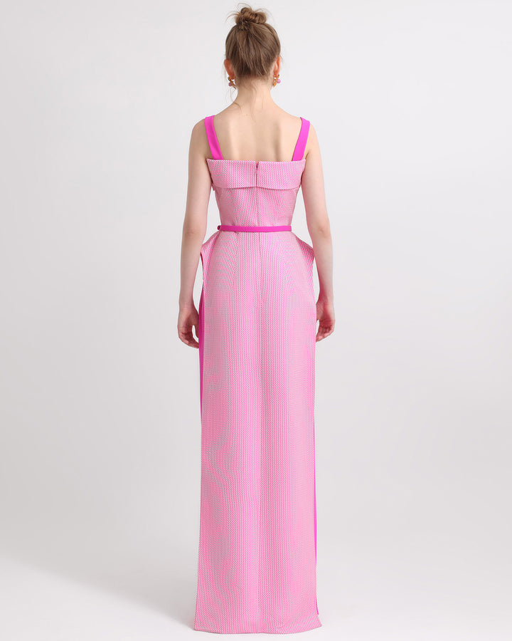 A floor length back of an asymmetrical two tone pink top with a detachable belt. 