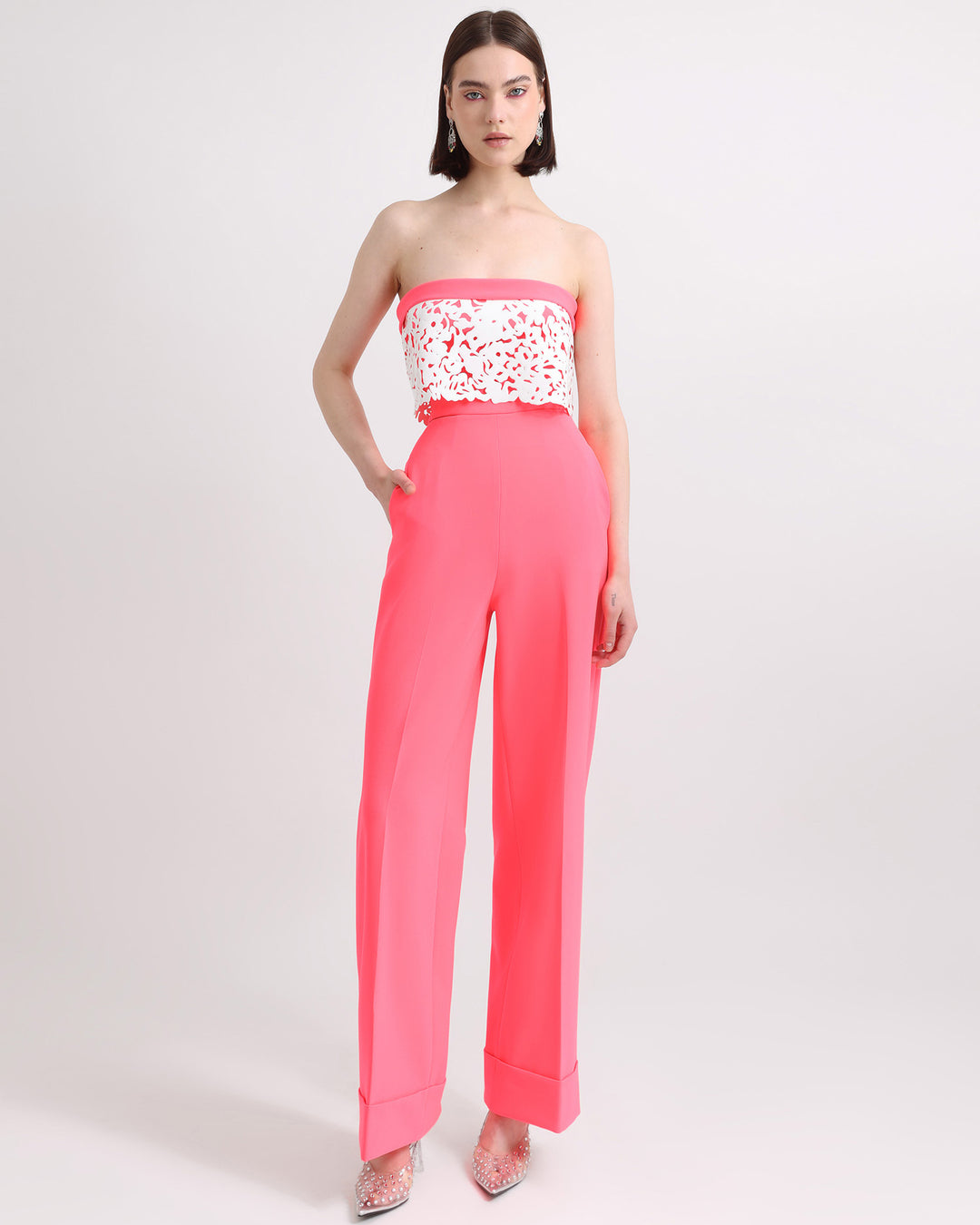 An occasion wear featuring a strapless neon pink top with white laser-cut silicon details matched with a straight cut pants in neon pink.