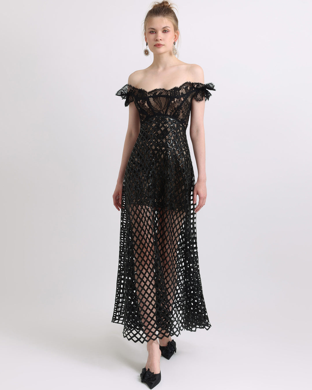 An off-shoulder sequins flared black dress with see-through details.