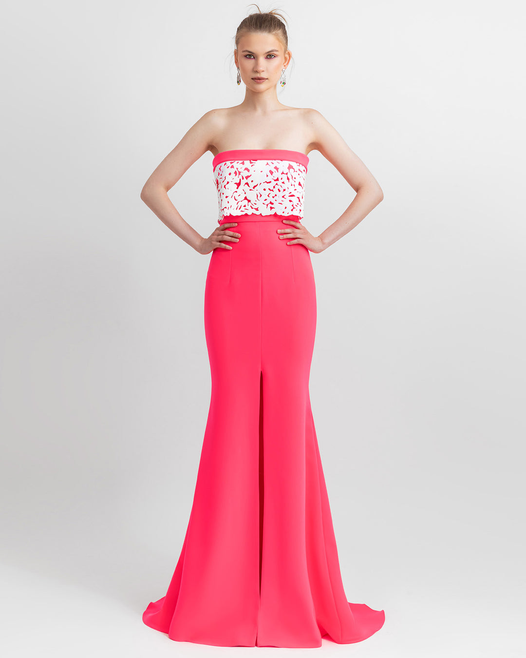 An occasion wear featuring a strapless neon pink top with white laser-cut silicon details matched with a neon pink mermaid cut skirt.