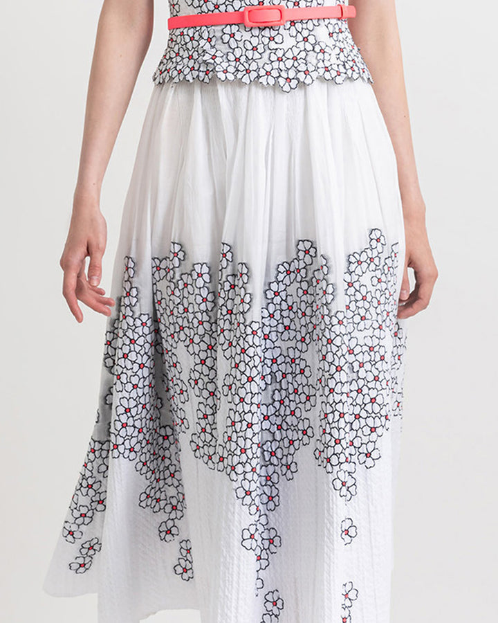 Close-up of a white jacquard midi flared skirt with flower motifs.