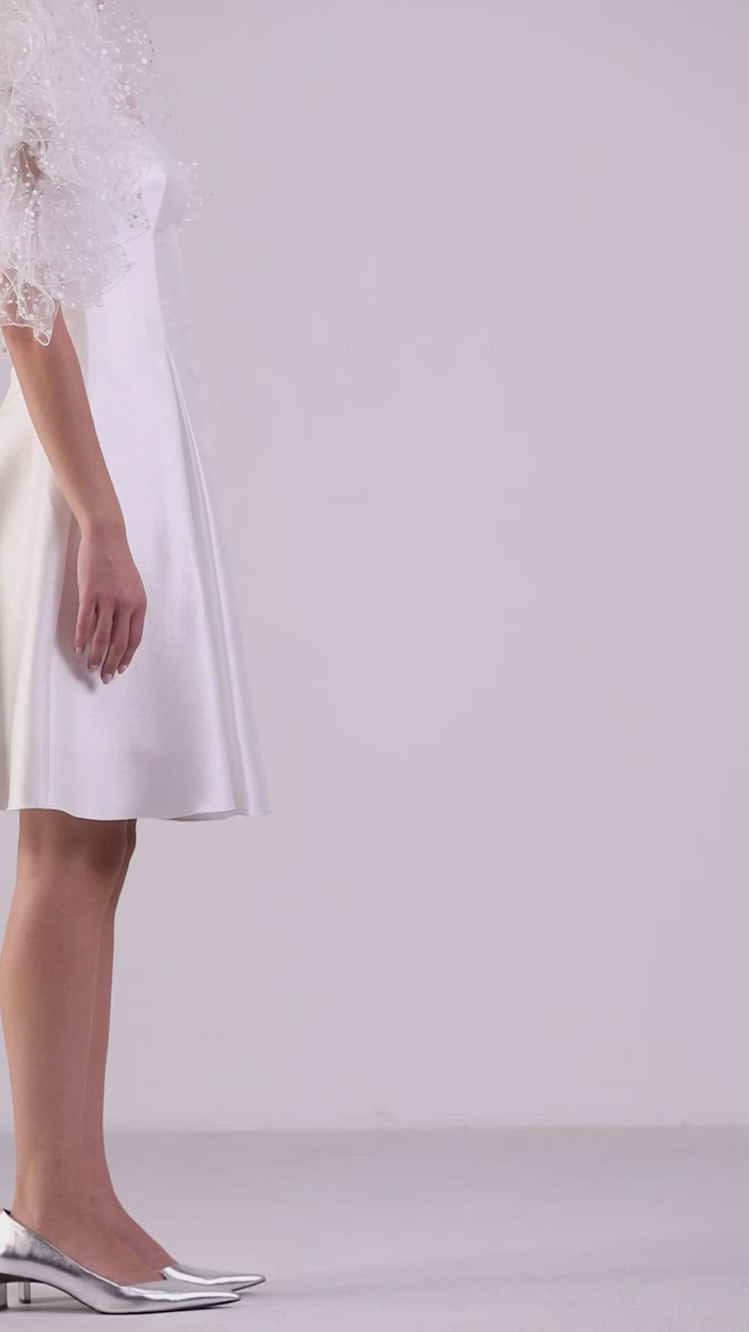 A princess cut ivory short dress, comes in a jacquard fabric featuring dramatical ruffled shoulders.