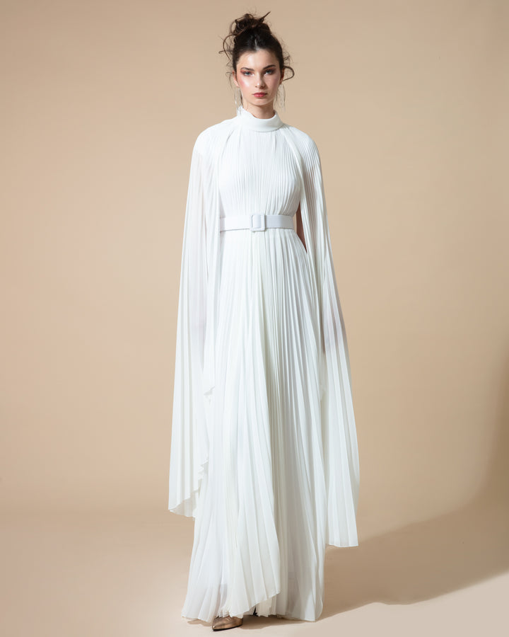 A fully pleated flared chiffon white kaftan dress with cape-like asymmetrical sleeves, paired with a detachable belt.