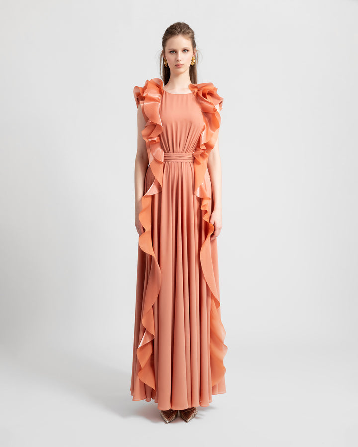 A flowy crepe copper evening dress featuring symmetrical ruffled details on the sides from the shoulders all the way down to the hemline.