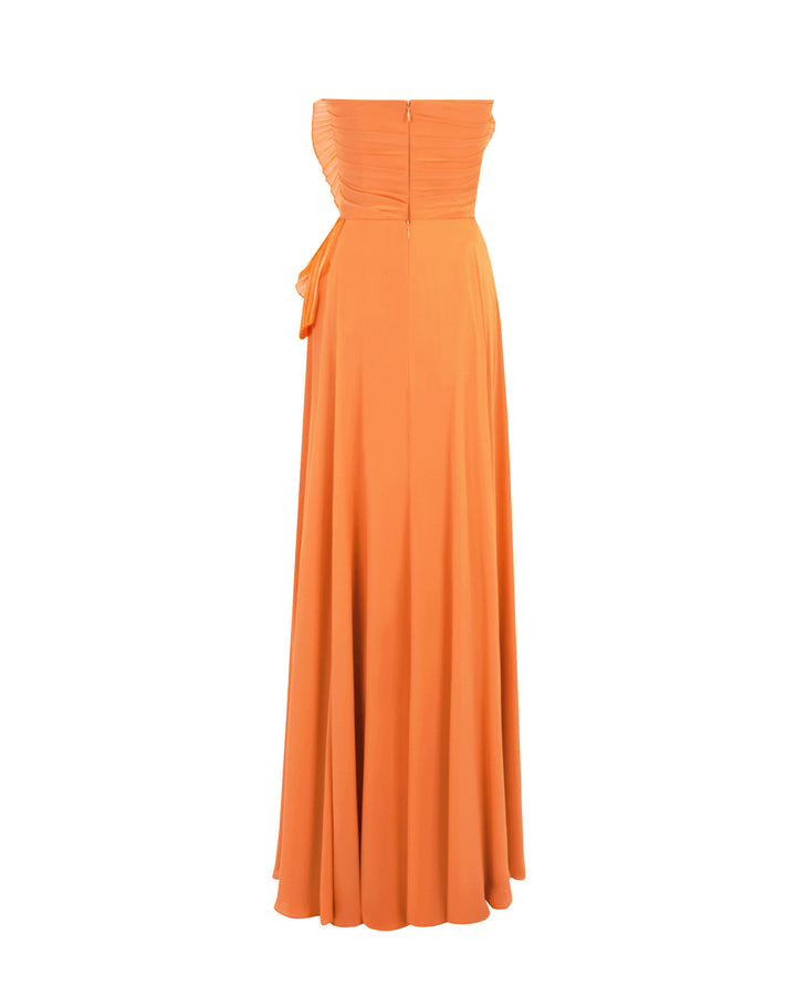 The back of an a-cut orange strapless crepe long evening dress featuring a gathered bodice design.