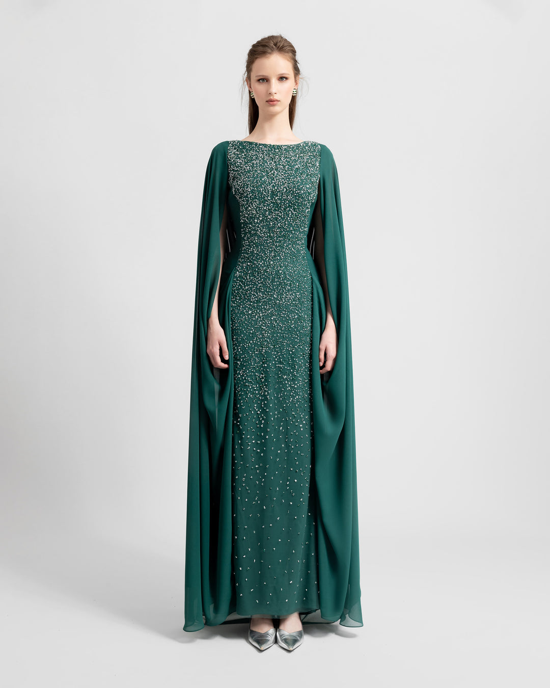 A straight-cut fully beaded long evening dress with a chiffon cape like sleeves, attached to the back making some draping.