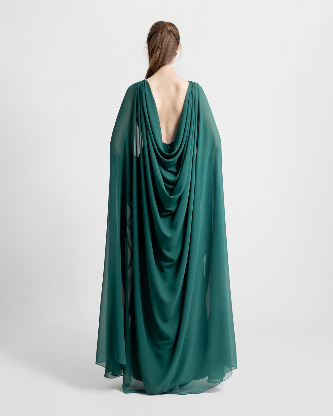 The back of a green long evening dress with a chiffon cape like sleeves and an open back 