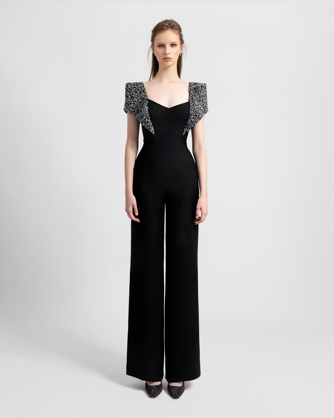 A straight-cut black crepe jumpsuit featuring fully beaded shoulders and an open back.