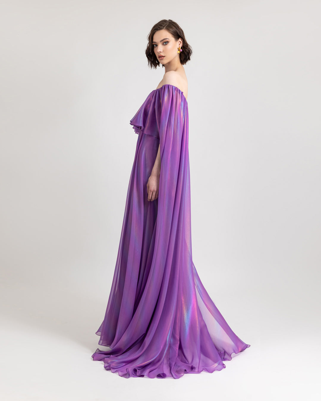 An off-shoulders cape like sleeves, flared cut purple evening dress with ruffled details.