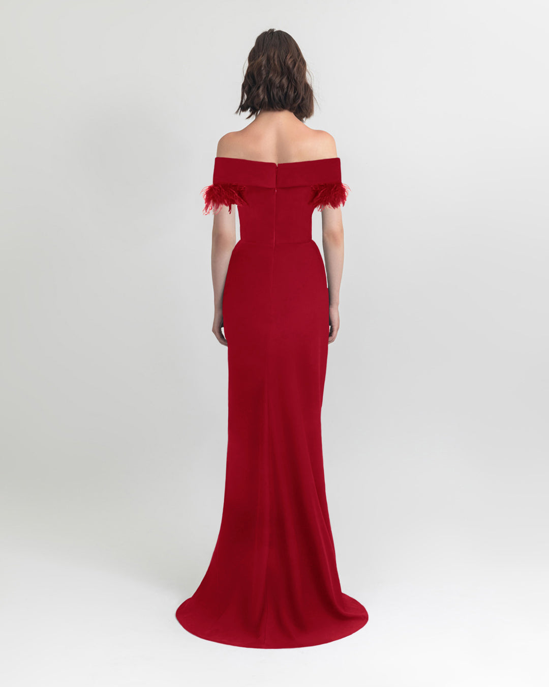 The back of a feathers off shoulder slim cut long red dress.