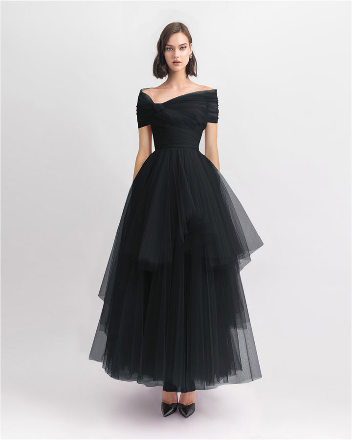 An off-shoulder bow-cut design black tulle dress with an asymmetrical lower part.