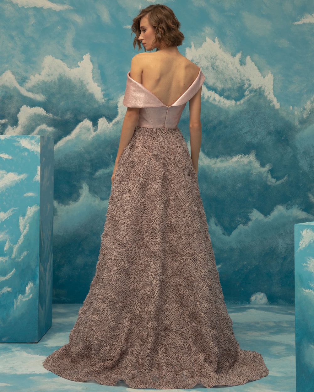 The back of a bi-fabric evening dress, asymmetrical woven metallic fabric upper part and wide fluffy textured chiffon cut skirt.