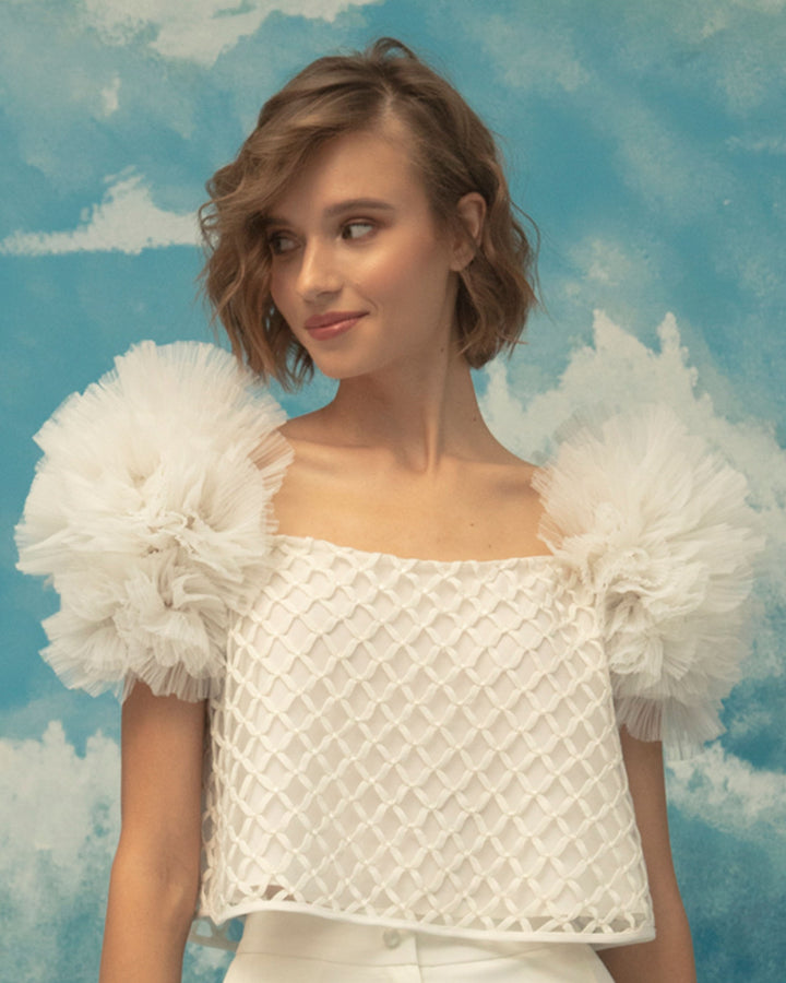 A squared neckline, embroidered fishnet ivory top, with puffed tulle shoulders.